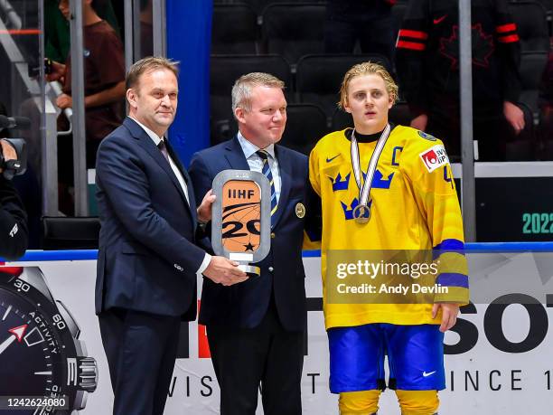 Henrik Bach Nielsen, IIHF Vice-President , Anders Larsson, IIHF Council Member , and Emil Andrae of Sweden pose with the bronze medal trophy...