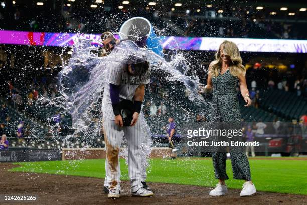 Brendan Rodgers of the Colorado Rockies gets doused with powerade by Charlie Blackmon as reporter Kelsey Wingert jumps out of the way after he hit an...