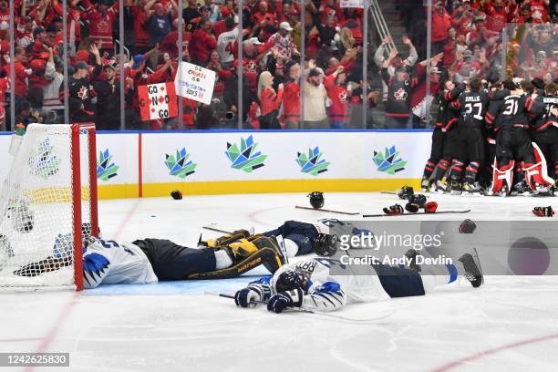 Juha Jatkola and Aatu Raty of Finland lay on the ice after losing the game to Canada in the IIHF World Junior Championship on August 20, 2022 at...