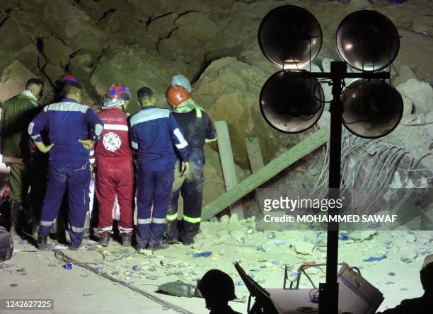An aerial picture shows members of Iraqi emergency services gathering near the rubble following a landslide at the Qattarat al-Imam Ali shrine on the...