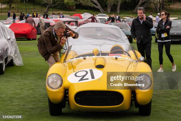 An attendee takes a photograph of a car at the 2022 Pebble Beach Concours d'Elegance in Pebble Beach, California, US, on Saturday, Aug. 20, 2022....