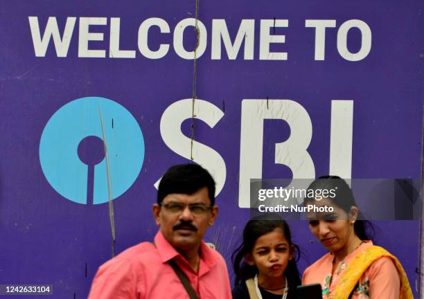 Family stands in front of SBI logo in Mumbai, India, 21 August, 2022.