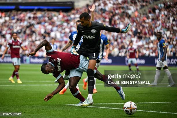 Brighton's Spanish goalkeeper Robert Sanchez tackles West Ham United's English midfielder Michail Antonio as he stops the ball during the English...