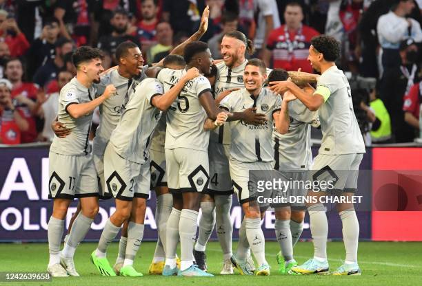Paris Saint-Germain's French forward Kylian Mbappe celebrates with his teammates after scoring his team's first goal during the French L1 football...