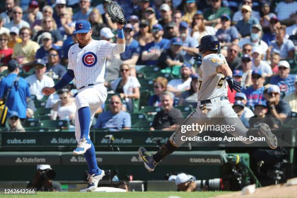 Higgins of the Chicago Cubs steps on first base ahead of Willy Adames of the Milwaukee Brewers for the out in the sixth inning at Wrigley Field on...