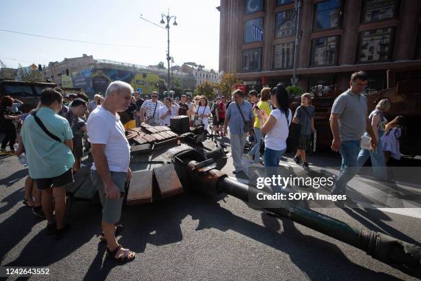 People look at the cannon of a destroyed Russian tank displayed on the main street Khreshchatyk as part of the upcoming celebration of the...