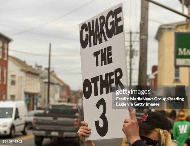 Boyertown, PA a protester holds a sign that reads "Charge the other 3" while standing along Philadelphia Ave holding signs. During a Boyertown Black...