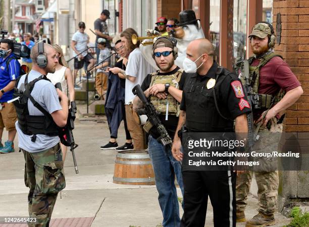 Boyertown, PA Three men carrying rifles who stood along Philadelphia Ave during the protest, talk with an Eastern Berks Regional Police Officer....