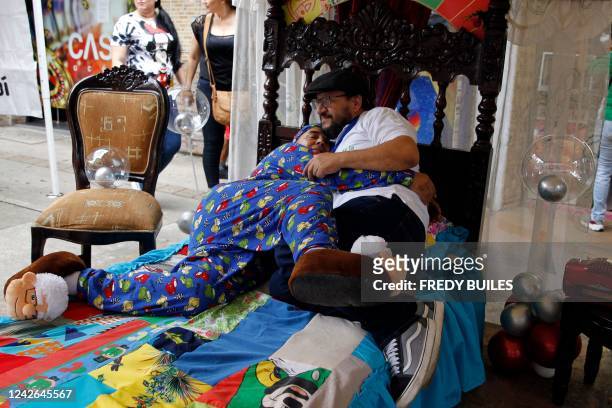Couple simulates to be asleep during the World Day of Laziness in Itagui, Colombia, on August 21, 2022.