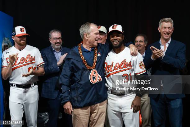Former President of the United States George W. Bush is presented with The Chain from Cedric Mullins of the Baltimore Orioles before the game between...