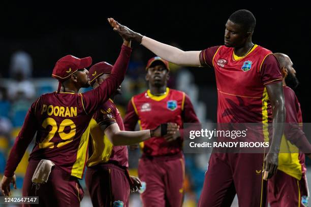 Nicholas Pooran and Jason Holder of West Indies celebrate the dismissal of Tom Latham of New Zealand during the 3rd and final ODI match between West...