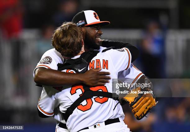 Felix Bautista celebrates with Adley Rutschman of the Baltimore Orioles after a 5-3 win over the Boston Red Sox at Bowman Field on August 21, 2022 in...