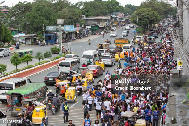 Guardians gather ahead of the dismissal time on the first day of classes outside an elementary school in Quezon City, the Philippines, on Monday,...