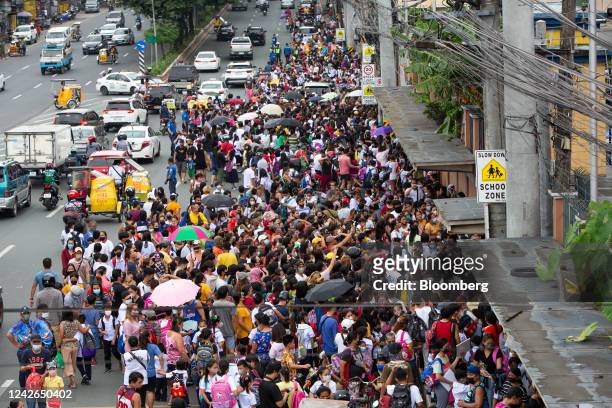 Guardians gather ahead of the dismissal time on the first day of classes outside an elementary school in Quezon City, the Philippines, on Monday,...