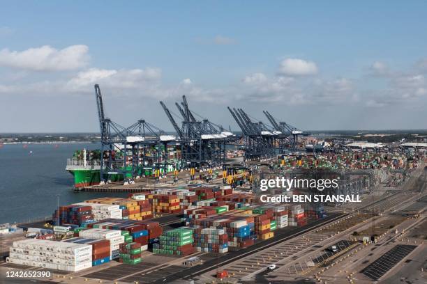 An aerial photograph taken on August 22, 2022 shows the Ever Alot container ship docked by stopped container loading cranes at the empty UK's largest...