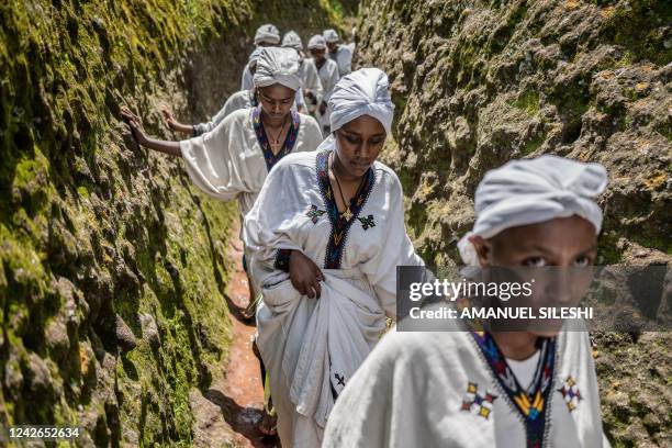 Young women walk through the cave of Saint George during Ashenda festival, at Saint George Church, in Lalibela, Ethiopia, on August 22, 2022. -...