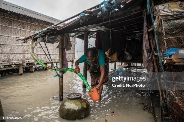 Woman tries to fill up her mag from the rainwater which comes from the pet bottle-made pipe at Kalabogi village in Khulna. Not too long ago Kalabogi,...