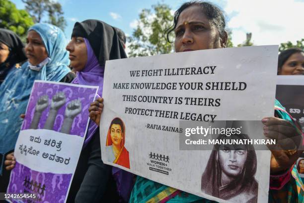 Activists hold placards during a protest against the release of men convicted of gang-raping Bilkis Bano during the 2002 communal riots in Gujarat,...