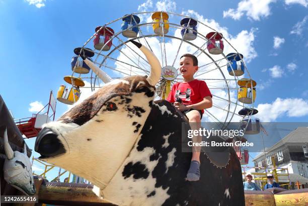 Marshfield, MA A boy hangs on during a mechanical bull ride at the Marshfield Fair. The 154th Marshfield Fair opened Friday and runs until August...