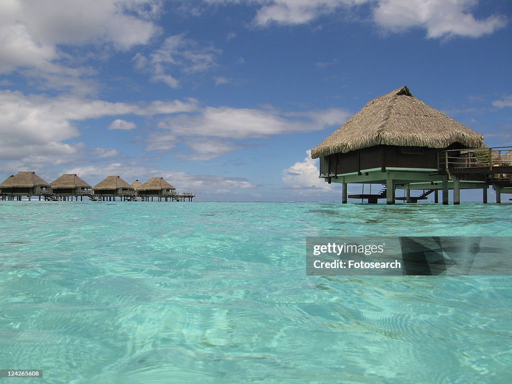 Thatch covered buildings on stilts built in the sea, Moorea, Tahiti, French Polynesia, South Pacific