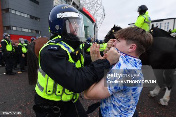 Protesters clash with police as they gather outside Old Trafford stadium to demonstrate against Manchester United's owners ahead of the English...