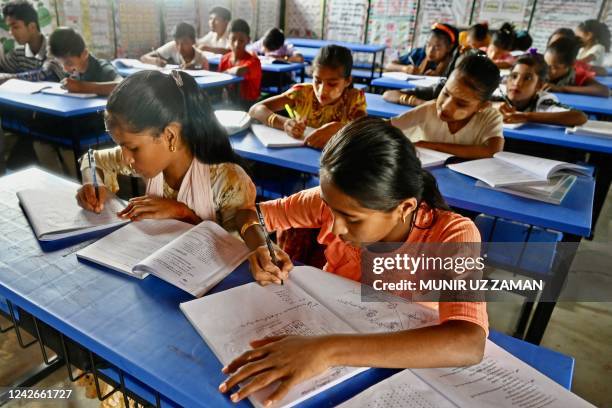 In this picture taken on August 10 Rohingya refugee children attend a class at a school in Kutupalong refugee camp in Ukhia. - The denial of...