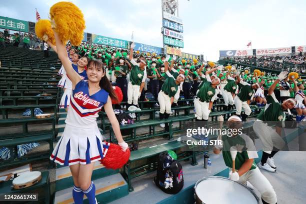 This photo taken on August 13, 2022 shows members of a school cheering section in the stands during their team's match on day 8 of the two-week...