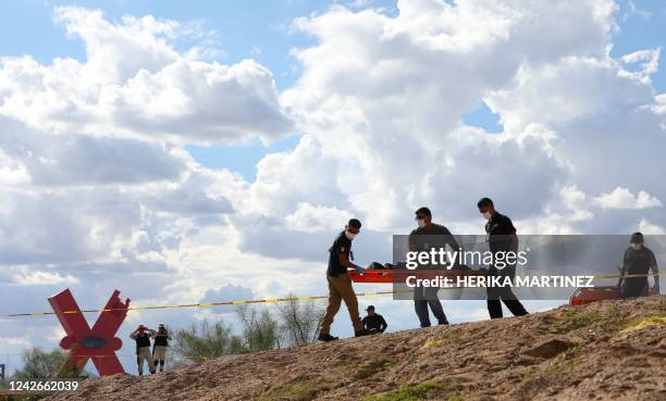 Forensic experts carry the body of a Guatemalan migrant girl who drowned while trying to cross with her mother the Rio Bravo, or Rio Grande, into the...