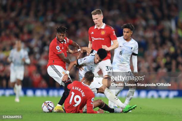 Luis Diaz of Liverpool is surrounded my Raphael Varane of Manchester United, Fred of Manchester United and Scott McTominay of Manchester United...