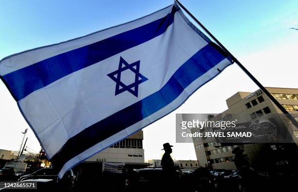 Policemen keep vigil as Israeli supporters wave flags during a demonstration in front of the Israeli consulate in Los Angeles, California, on January...