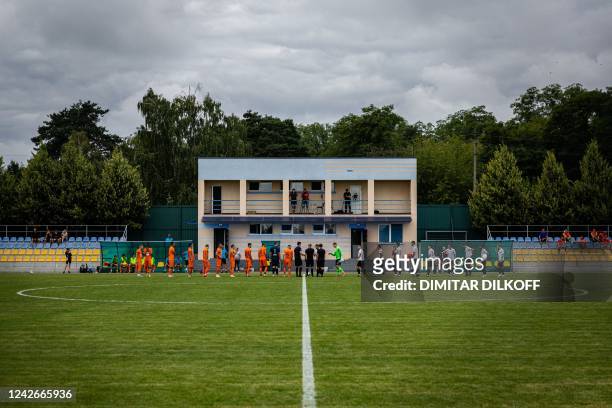 Mariupol's players and FC Nyva congratulate each other prior their warming-up match at a tiny Demydiv village stadium 20 kilometres north of Kyiv, on...