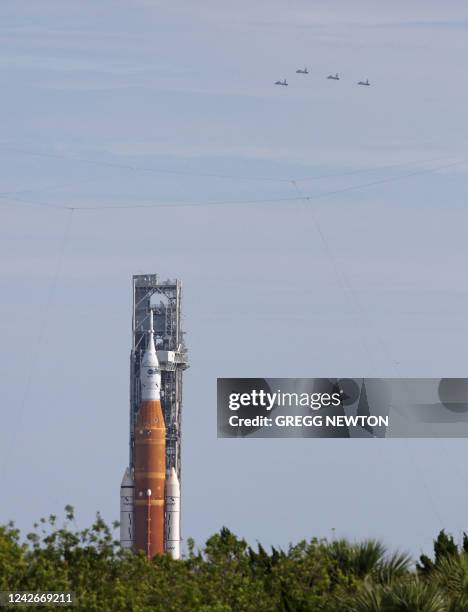 Four members of the NASA astronaut corps execute a flyover of Launch Pad 39B in T-38 Talon jets over the Artemis I Moon rocket on the launch pad at...