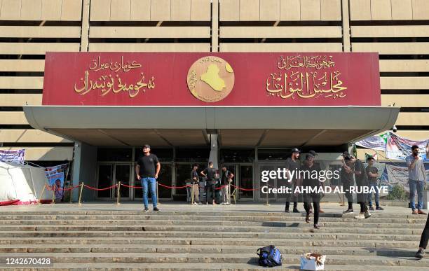 Supporters of Iraqi Shiite cleric Muqtada al-Sadr stand outside the Iraqi parliament in the Green Zone of the capital Baghdad, on August 23 near...