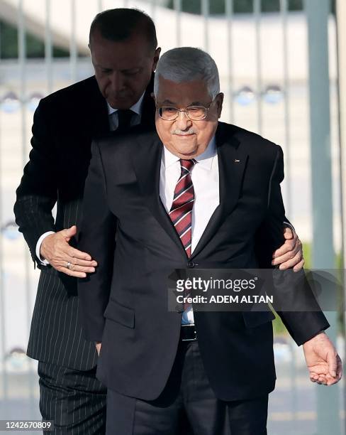 Turkey's President Recep Tayyip Erdogan walks with Palestinian President Mahmoud Abbas prior to their meeting during an official welcome ceremony at...