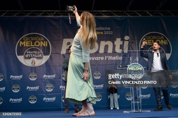 Leader of Italian far-right party Fratelli d'Italia Giorgia Meloni takes a selfie on stage during a rally to launch her campaign for general...