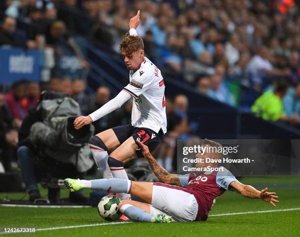 Bolton Wanderers' Conor Bradley battles with Aston Villa's Lucas Digne during the Carabao Cup Second Round match between Bolton Wanderers and Aston...