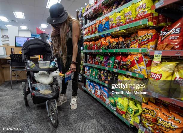 Autumn McWilliams offers a treat to her emotional support animal, a male, Pekin duck she named Cardi D, while shopping inside a CVS store on 8th St....