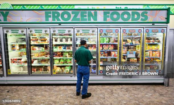 Man looks at frozen foods for sale at a Dollar Store in Alhambra, California on August 23, 2022. - US shoppers are facing increasingly high prices on...