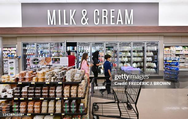 Shoppers walk through the milk and cream section of a supermarket in Montebello, California, on August 23, 2022. - US shoppers are facing...