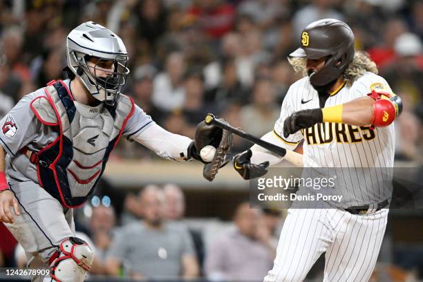 Austin Hedges of the Cleveland Guardians tries to tag Jorge Alfaro of the San Diego Padres after a dropped strike three in the eighth inning August...