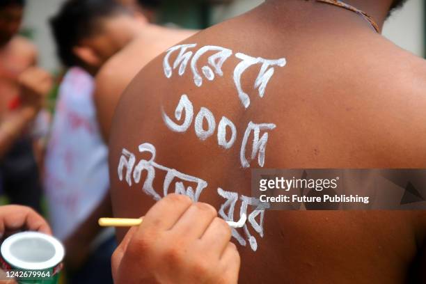Bangladeshi tea plantation workers strike to demand an increase in wages. The workers are protesting by writing slogans on their bodies, such as 'Pay...