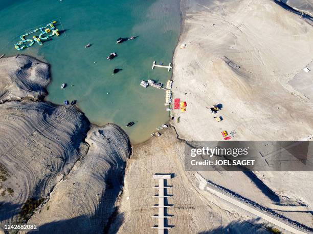 This aerial view taken on August 23 shows boarding pontoons on a dry section of the Serre-Ponçon lake as water levels decreased some 14 meters due to...