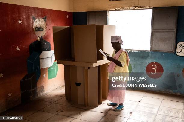 Woman folds her ballot paper at a voting booth in Luanda on August 24 during Angola's general elections. - Angolans started casting ballots on August...