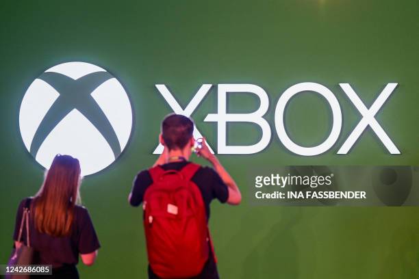 Visitors take a photo of the Xbox logo at the Gamescom video game fair in Cologne on August 24, 2022. According to the organisers, around 1,100...