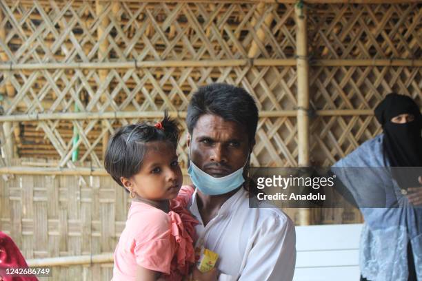 Rohingya refugee, who came to Bangladesh after persecution from Myanmar five years ago, takes his child to health center, in Cox's Bazar, Bangladesh...