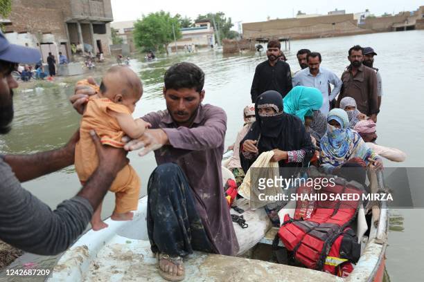 Residents arrive in a boat to a safer place after being evacuated following heavy monsoon rainfall in the flood affected area of Rajanpur district in...