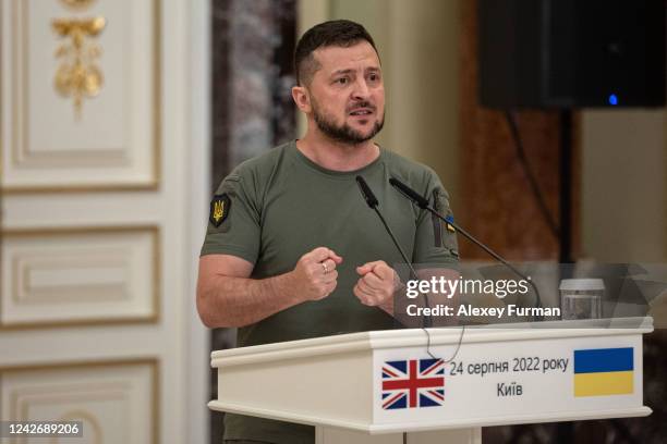 Ukrainian President Volodymyr Zelensky speaks while standing next to British Prime Minister Boris Johnson as they give a press conference on August...