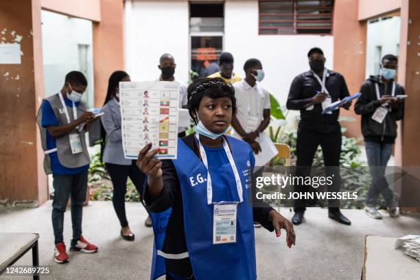 An election official holds up a ballot paper as votes are counted at a polling station in Luanda on August 24 during Angola's general elections. -...