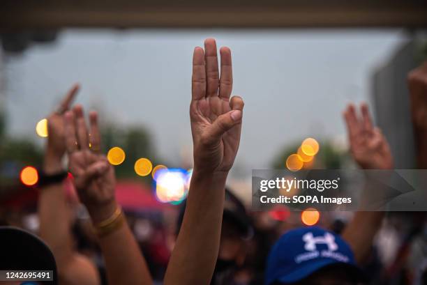 Protesters seen gesturing the three finger salute during the demonstration. Anti government protesters gathered outside the government house to...