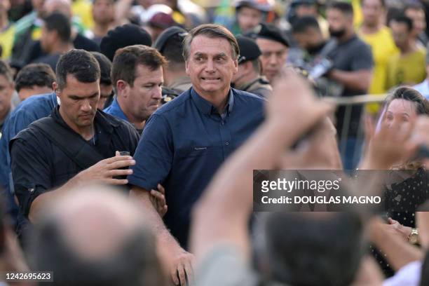 Brazil's President Jair Bolsonaro is greeted by supporters after taking part in a motorcade rally as part of his re-election campaign, at Praca da...